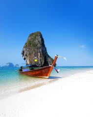 White sand beach and boat on sea coast of Thailand. Vertical background