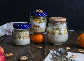 oatmeal, granola, nuts and honey in a pot on a wooden board