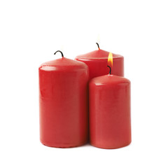 Three burning red candles isolated