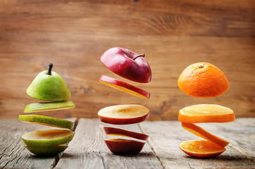 flying slices of fruit: apple, pear, orange