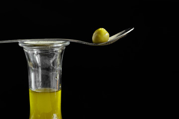 löffel mit olive auf einer flasche