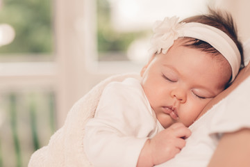 Portrait of sleeping baby in home and window is behaind