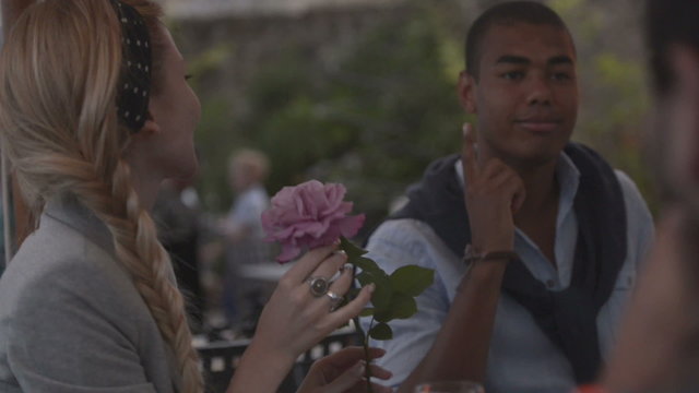 Man at italian restaurant present a rose to a woman