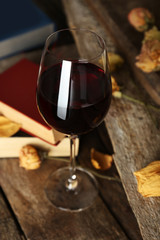 Beautiful composition with glass of wine with old books on table close up