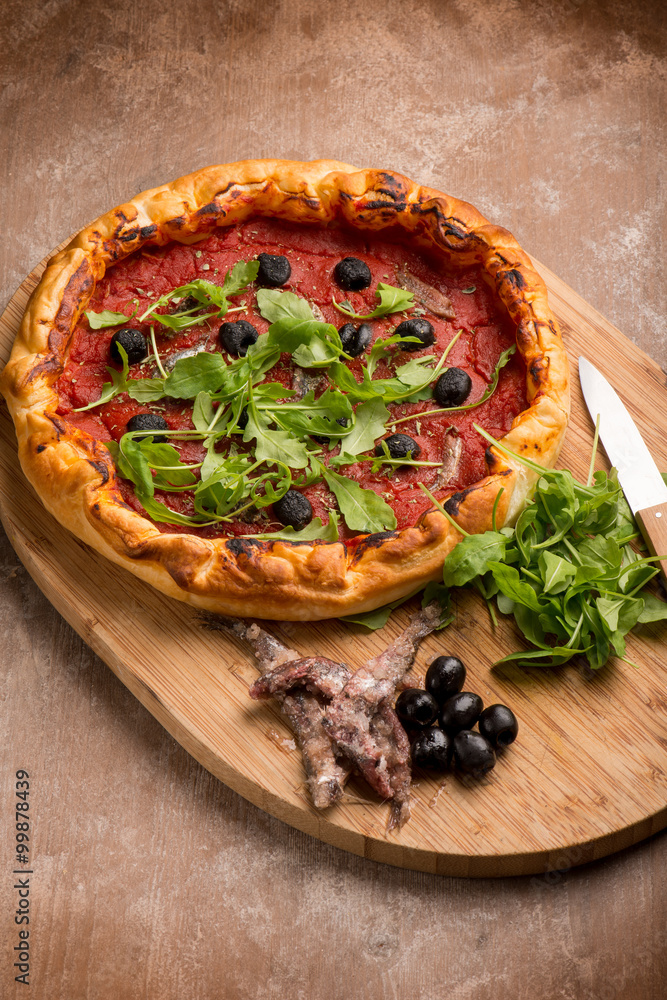 Poster pizza with anchovies black olives and arugula