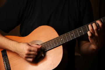 Fototapeta premium Young musician playing acoustic guitar close up