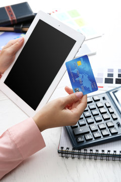 Concept for Internet shopping: hands with digital tablet and credit card