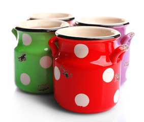Old colourful milk cans with polka dots, isolated on white