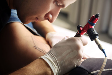 Tattooist makes tattoo, close up