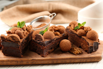 A piece of chocolate cake with walnut and mint on the table, close-up