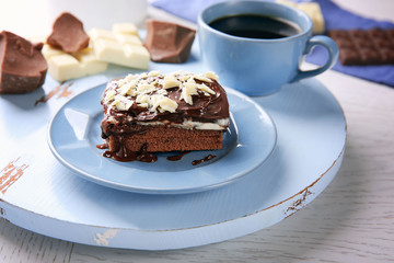 Delicious chocolate brownie on plate on wooden background