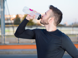 Man drinking water in urban park