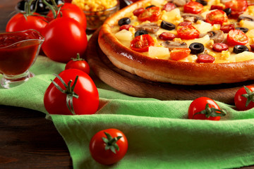 Delicious pizza with vegetables and meat on green napkin, close-up