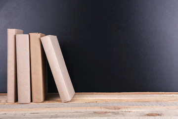 Books on a table on blackboard background