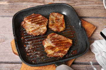 Roasted beef fillet on pan, on wooden background