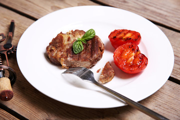 Roasted beef fillet on plate, on wooden background