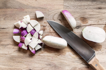 slices of fresh purple turnip on an oak cutting board