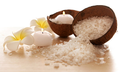 Spa concept of plumeria, coconut and candles with sea salt, isolated on white
