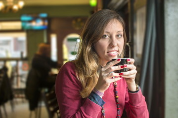 young brunette drinking coffee at a coffee shop