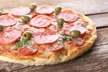 Delicious tasty pizza on wooden background