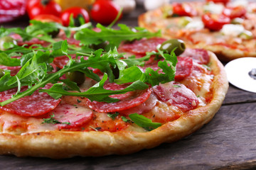Delicious tasty pizzas with ingredients on table, closeup