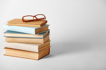 Pile of books and eyeglasses on it isolated on white background