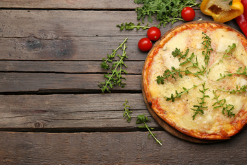 Tasty pizza decorated with herbs and vegetables on wooden background, close up