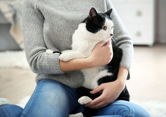 Woman with beautiful cat on carpet, indoor