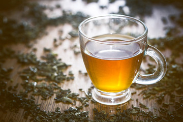 Green tea transparent cupon wooden table.