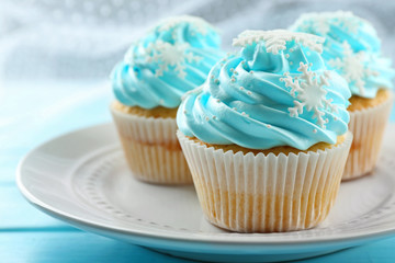 Blue cakes on plate on wooden background