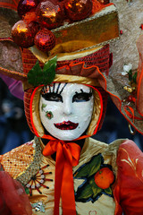 Costumed person with colorful Venetian Carnival mask in Venice, Italy.