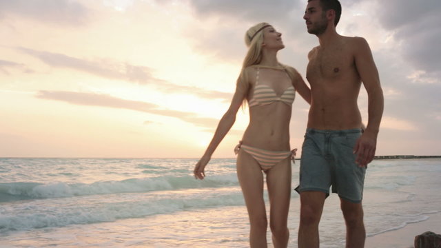 Front view couple walks along sea side  gimbal steadicam  