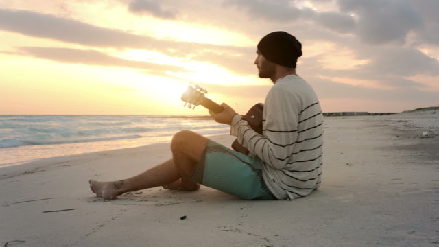 Man plays guitar at sea side  gimbal steadicam  