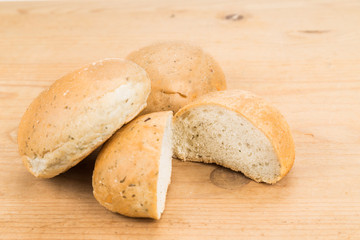 Freshly baked healthy gluten-free delicious wholemeal buns with herbs on wooden surface