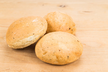 Freshly baked healthy gluten-free delicious wholemeal buns with herbs on wooden surface