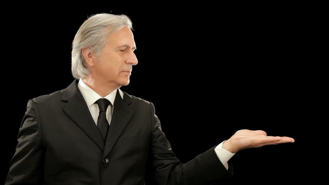 Middle age elegant businessman gesturing  isolated on black  