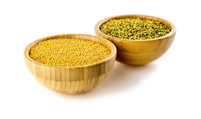 Macro of yellow mustard seeds next to coriander pods