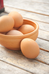 eggs in a wooden bowl on the table from the old boards