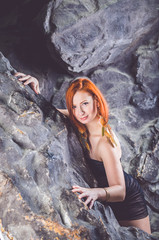 Redheaded girl posing on the rocks