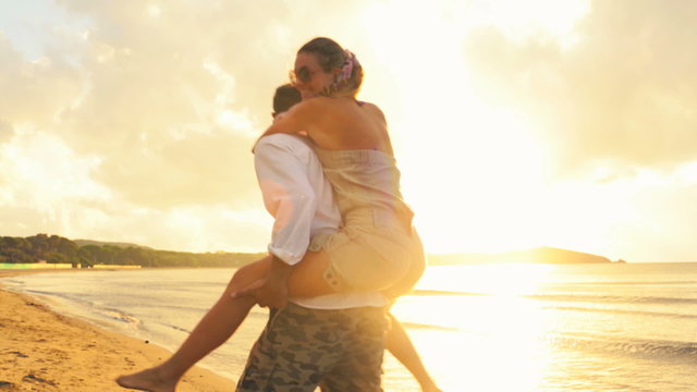 Couple have fun on beach at sunset