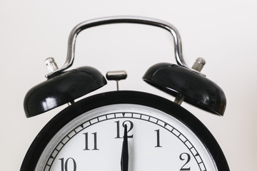 Black alarm clock showing 12 o'clock