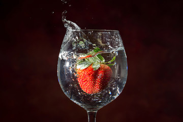 strawberry drop on water, splashing out glass