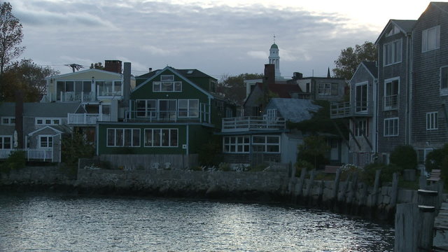 Buildings around the end of Rockport Harbor at sundown.