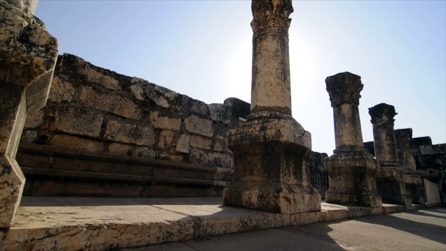 Slow-moving tracking footage of ruined columns in a row near crumbling wall