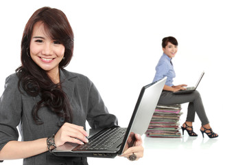Young asian businesswoman, with her team behind holding laptop.