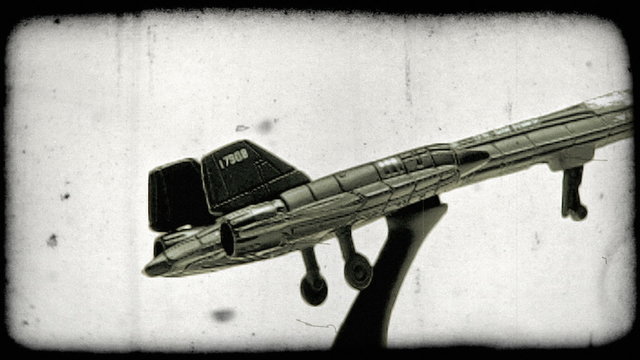 A model SR-71 airplane rotating in a circular motion from stationary point. Vintage stylized video clip.