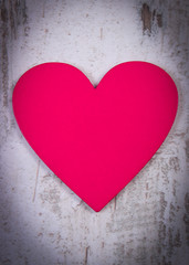 Valentine pink heart on old wooden white table, symbol of love