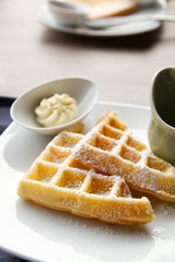 waffle with icing sugar, butter, syrup