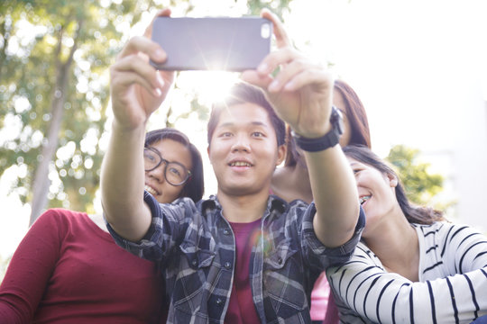 Group of Friends taking Self Portraits with Mobile Phone