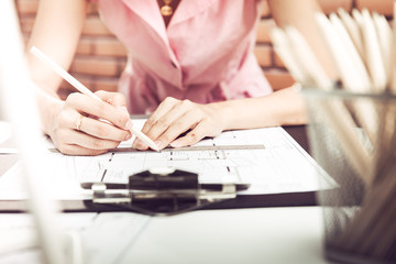 Female architect working at home.She looking at blueprint.